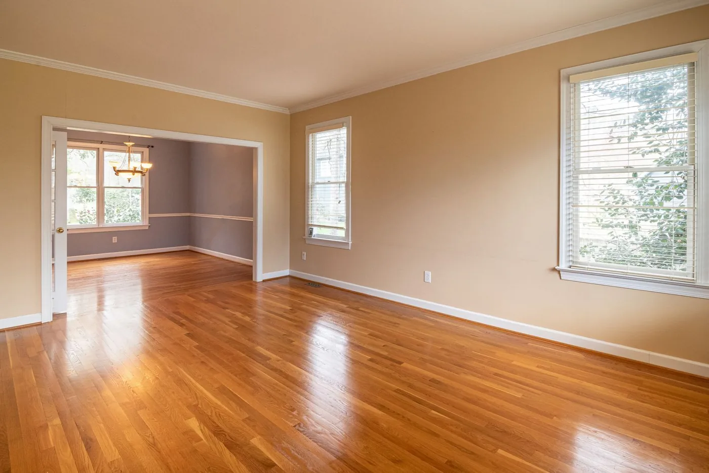 Bright empty room with warm hardwood flooring and large windows